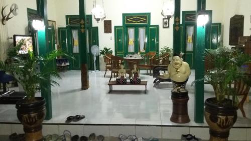 a room with green doors and a room with a statue at Pendopo Andari Homestay in Yogyakarta