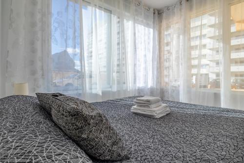 een slaapkamer met een bed met kussens en een raam bij Inftour President 2 Apartamento in Calpe
