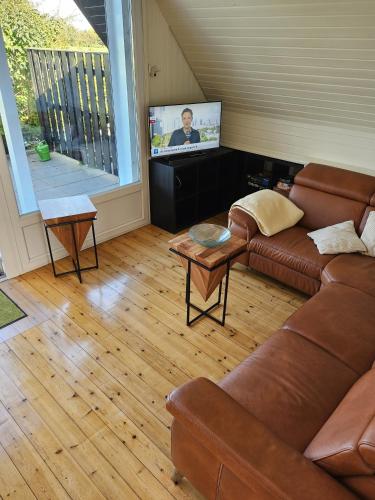 a living room with a couch and a flat screen tv at Zum Leuchtturm in Heiligenhafen