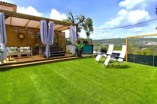 un cortile con un prato, tavolo e sedie di Charmant studio avec terrasse et jardin au cœur de la Provence 4 étoiles a Camps-la-Source