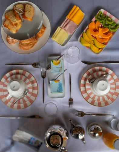 a table with plates of food and utensils at Elsi Pousada in Búzios