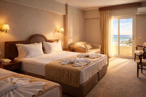 une chambre d'hôtel avec deux lits et un balcon dans l'établissement Kayhanbey Hotel, à Kusadası