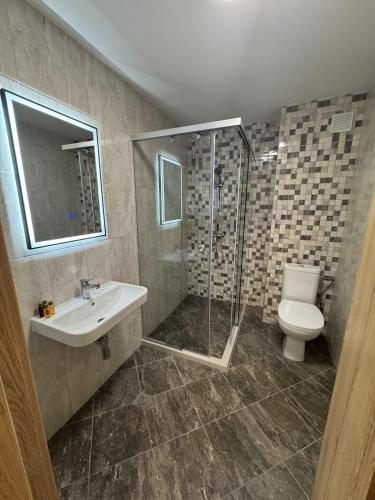 a bathroom with a shower and a toilet and a sink at Alen Mak in Govedartsi