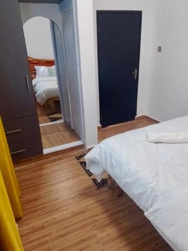een slaapkamer met een wit bed en een spiegel bij Terus studio in Nanyuki