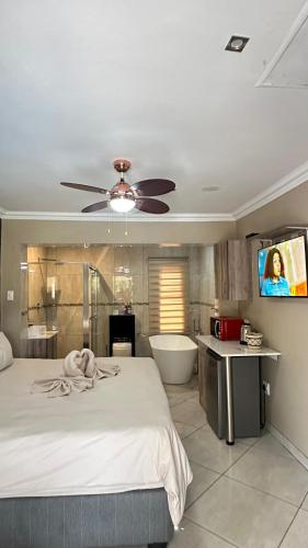 a bedroom with a bed and a tv and a tub at Sunrise Boutique Hotel in eMalahleni