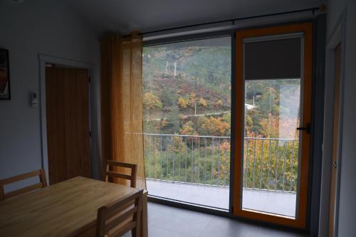 a dining room with a large window and a table at MedronHouse - Casa de Campo in Vasco Esteves de Baixo