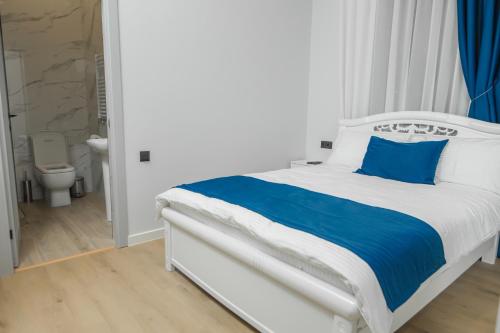 een wit bed met blauwe kussens in een slaapkamer bij Barca Hotel in Jerevan