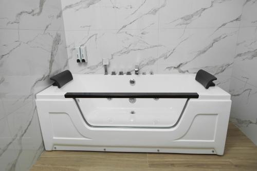 un lavabo blanc dans une salle de bain aux murs en marbre dans l'établissement Barca Hotel, à Erevan