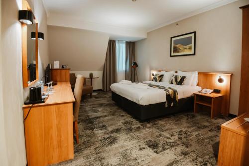 een hotelkamer met een bed en een bureau bij Hotel Karpos in Skopje