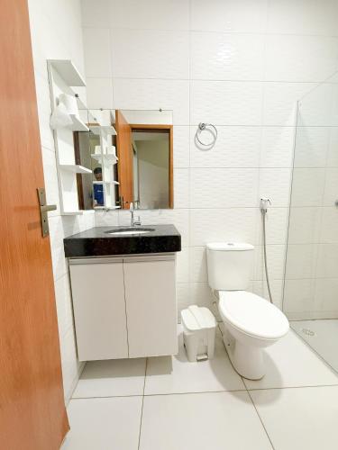 a white bathroom with a toilet and a sink at Pousada Cidade Nova in Campo Maior