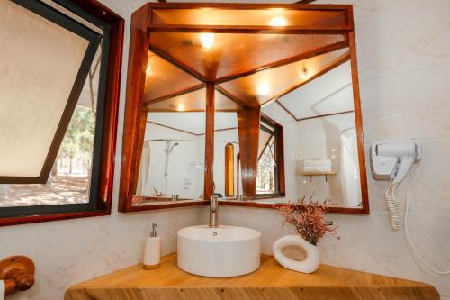 a bathroom with a sink and a mirror at Pao Pao Lodge Algarrobo in Algarrobo