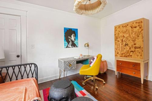 a bedroom with a desk and a yellow chair at Lucky Leopard in Atlanta