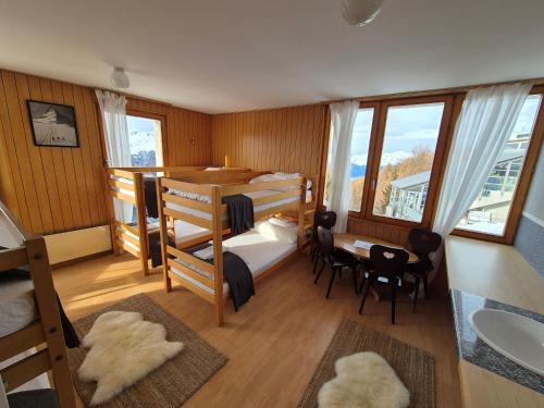 een kamer met 2 stapelbedden en een tafel en stoelen bij Tignousa logement de groupes et individuels in Saint-Luc