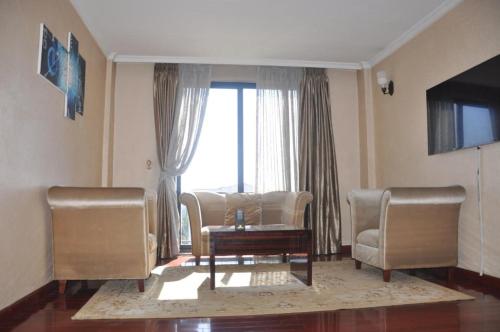 een woonkamer met twee stoelen en een salontafel bij Foyat Hotel in Addis Ababa