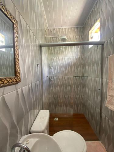 a bathroom with a toilet and a sink and a mirror at Pousada Mont Hebrom in Ibicoara