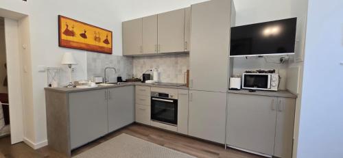 a kitchen with white cabinets and a microwave at Bivar Urban Retreat in Lisbon