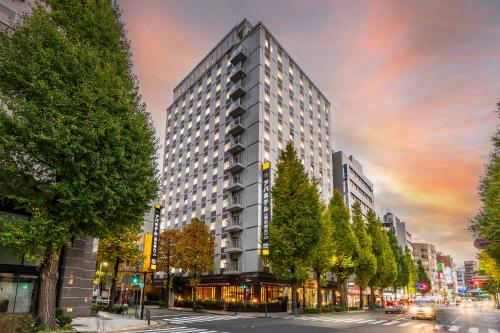 a rendering of a tall building on a city street at APA Hotel Yokohama Kannai in Yokohama