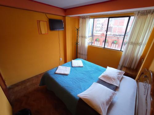 een slaapkamer met een bed met twee handdoeken erop bij WILLKA Hostel in Copacabana