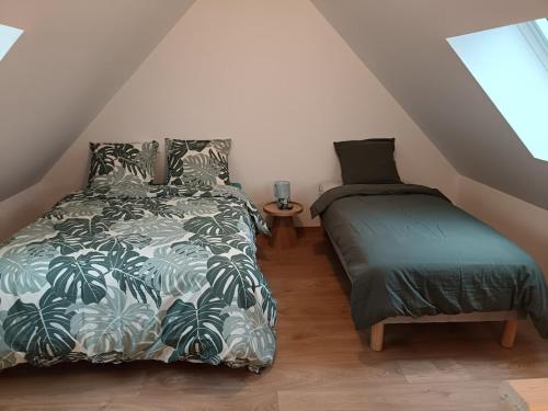 een slaapkamer met een bed en een nachtkastje met een bed en een bedrok bij Maison Les Escardines in Oye-Plage