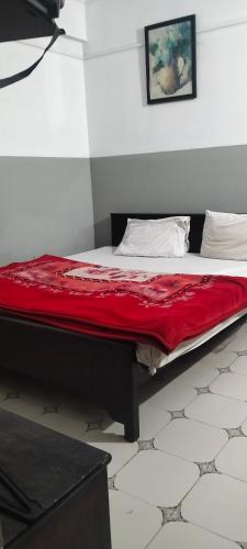 a bed in a room with a red blanket on it at Hamala Inn Hotel in Abbottabad