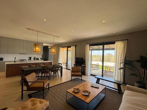 een woonkamer met een bank en een tafel en een keuken bij Casa en Maitencillo in Puchuncaví