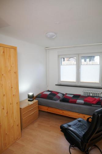 a bedroom with a bed and a window and a chair at Schöne Unterkunft mit Billard in Meinerzhagen