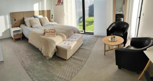 una camera da letto con un letto, un tavolo e delle sedie di Alsace Elégance Suite a Wittelsheim