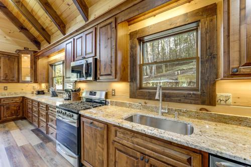 una cucina con mobili in legno e un lavello di Riverfront Cabin with Mtn Views in Robbinsville a Junction