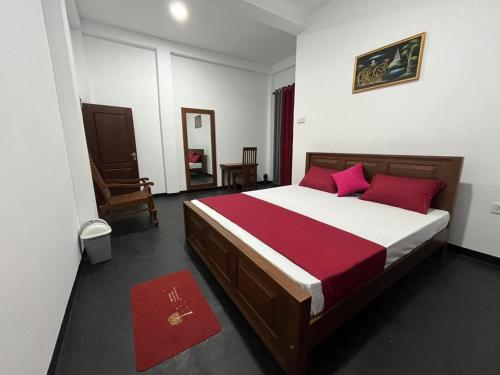 a bedroom with a large bed with red pillows at Double T in Dickwella