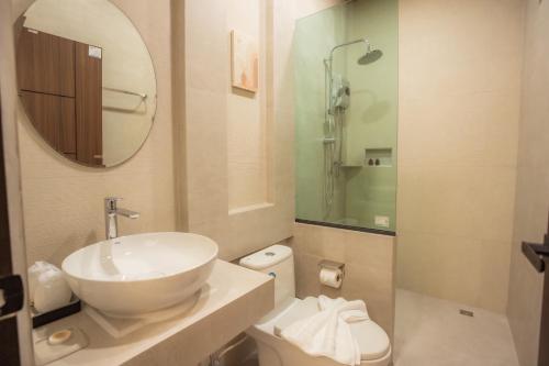 een badkamer met een wastafel, een toilet en een spiegel bij Annrin cafe & Resort in Ban Song Phi Nong