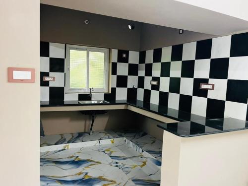 a room with a checkered wall with a desk and a window at Villa D Amour in Pondicherry