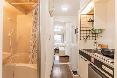 eine kleine Küche mit einem Waschbecken und einer Badewanne in der Unterkunft sakura 405 in Tokio