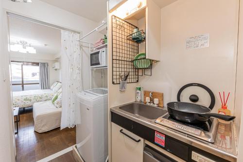 eine kleine Küche mit Spüle und Herd in der Unterkunft sakura 405 in Tokio