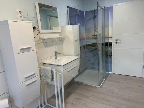 a white bathroom with a sink and a shower at Ferienwohnung Lena in Morbach