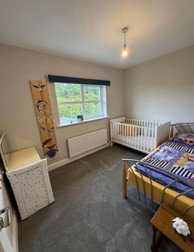 a bedroom with a bed and a crib and a window at Lighthouseview - Cahersiveen in Cahersiveen