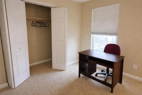 een kamer met een bureau, een stoel en een raam bij Private room with a private full bathroom in Woodbridge