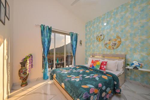 ein Schlafzimmer mit einem Bett mit blauen Wänden und einem Fenster in der Unterkunft EMPYREAN STAY II LEONCINO VILLA II 4BHK II AC II LARGE POOL lI WIFI II BBQ in Lonavla