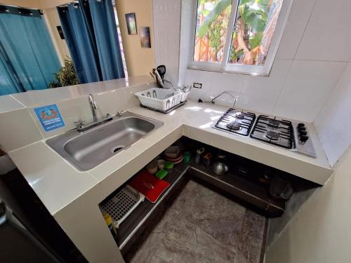 een kleine keuken met een spoelbak en een fornuis bij Posada Cedar Valley in Providencia
