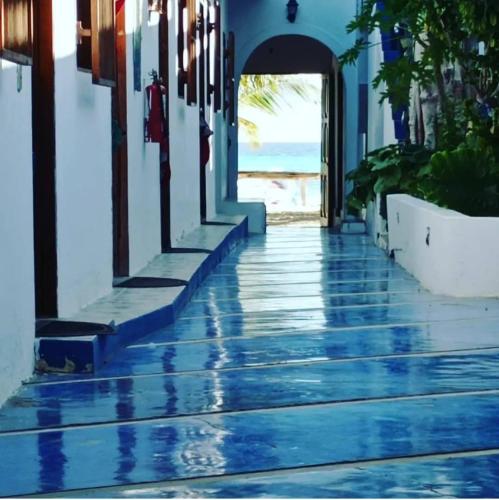 a hallway with a blue and white building and the ocean at Posada Doña Carmen in El Roque