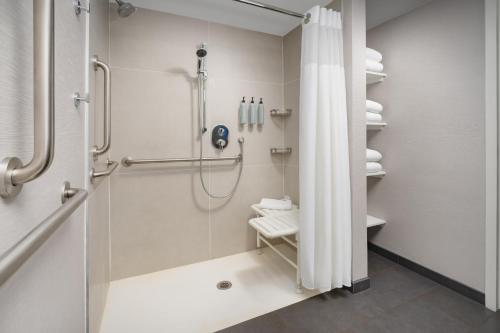 ein Bad mit Dusche und Duschvorhang in der Unterkunft Courtyard Chicago Midway Airport in Bedford Park