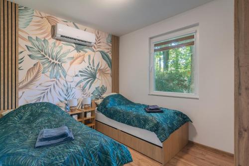 a bedroom with two beds and a window at Fácán Fészek Vendégház in Mátraszentimre