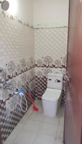 a bathroom with a toilet and a red mop at Khans villa in Hyderabad