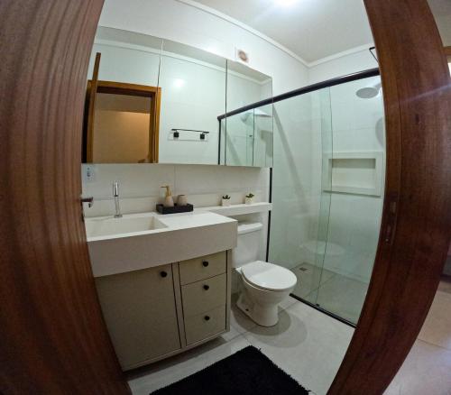 een badkamer met een toilet, een wastafel en een douche bij Brisa Mar e Cachoeira in Governador Celso Ramos