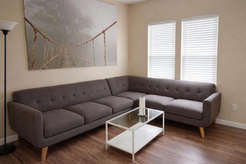 een woonkamer met een bank en een glazen tafel bij Private room with a private full bathroom in Woodbridge