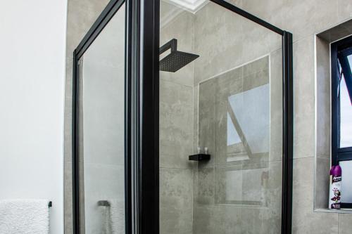 eine Dusche mit Glastür im Badezimmer in der Unterkunft Luxury 1 Bed Apartment in Sandton