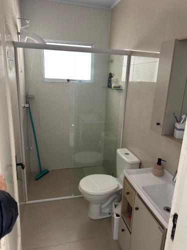 a bathroom with a shower and a toilet and a sink at Conforto a 100 m do mar in Tramandaí