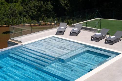 una piscina con un gruppo di sedie e un tavolo di Villa Fabris by Briskva a Kringa