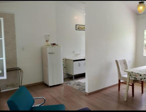 a kitchen with a refrigerator and a table and chairs at Sitio JP in Pindamonhangaba
