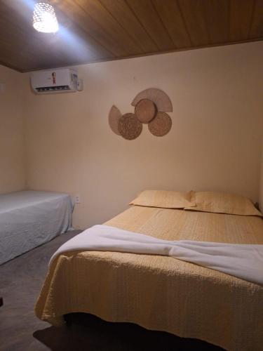 een slaapkamer met een bed en een schilderij aan de muur bij Vila Borogodó BG in Barra Grande