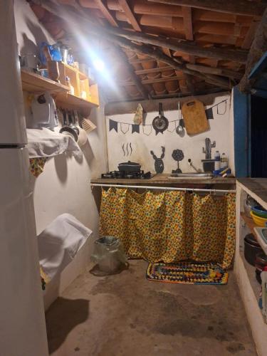 een keuken met een fornuis en een gordijn ervoor bij Vila Borogodó BG in Barra Grande